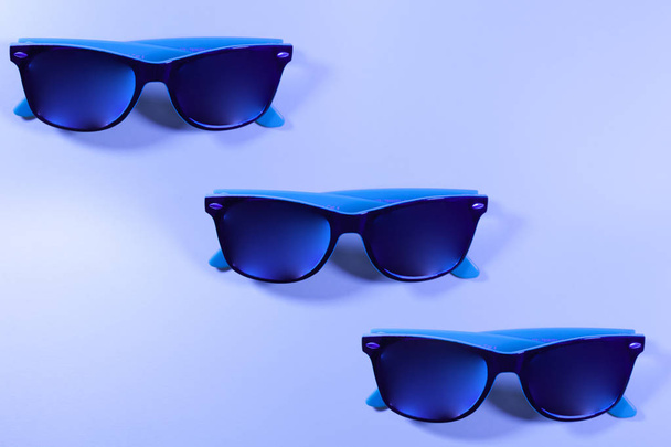 Tres pares de gafas azules sobre un fondo azul
 - Foto, imagen