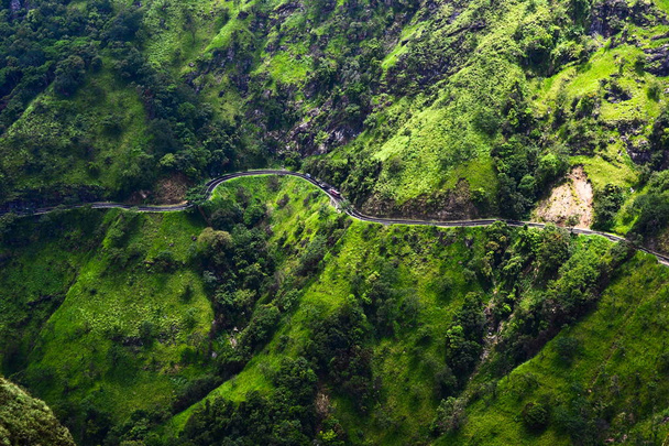 Curved mountain road with small cars and bus from aerail view. Bright green colored grass on rocky mountains. Fresh colored landscape. Great bright detailed travel nature wallpaper. Ella, Sri Lanka - Foto, Imagen