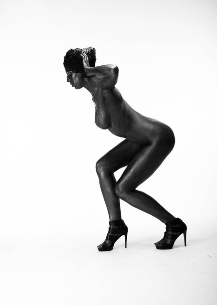 Naked woman painted in black on a white background in the studio - Foto, immagini