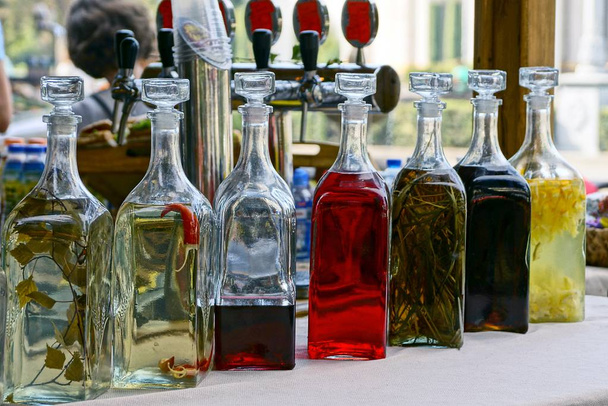 Botellas de vidrio cerradas con bebidas de colores en la mesa
 - Foto, imagen