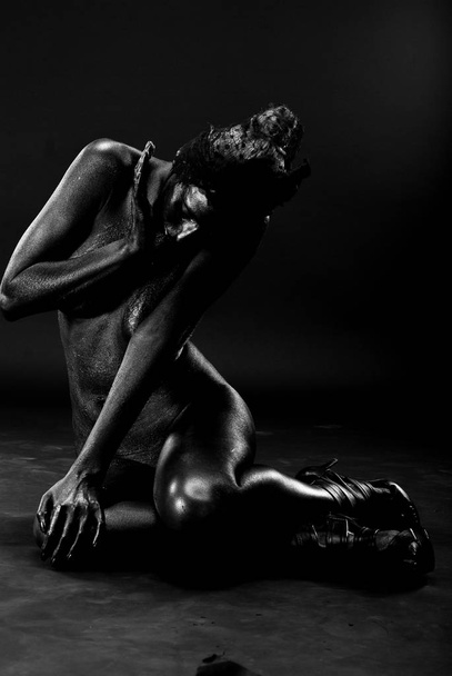 Naked woman painted in black on a white background in the studio. - Foto, imagen
