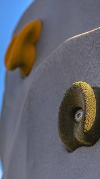Panorama Close up of the foot and hand holds on a climbing wall against bright blue sky - Photo, Image