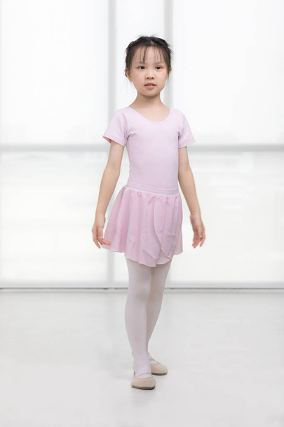 Рожева одягнена азіатка в балетну позу. - Фото, зображення