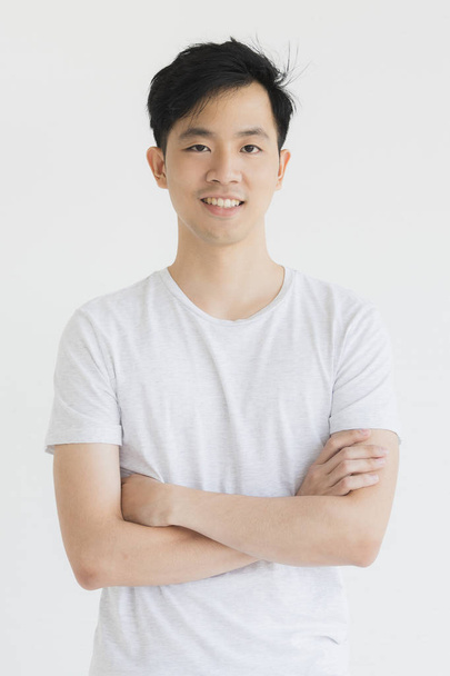 Joven hombre asiático modelo en camiseta cruzada brazo
 - Foto, imagen