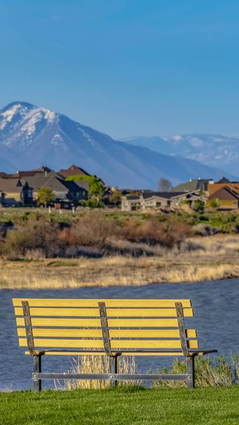 Panorama frame Bench with a scenic view of lake and snow capped mountain against blue sky - Photo, Image