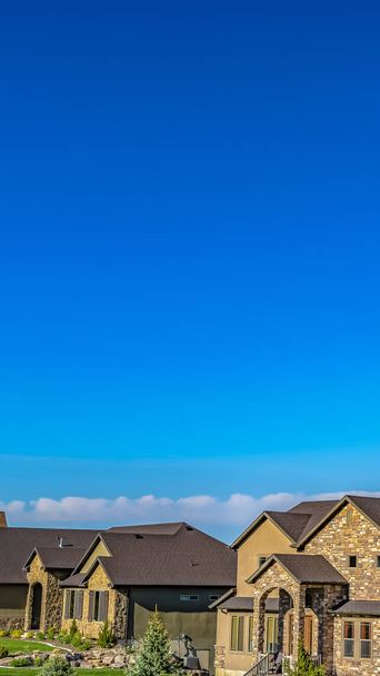 Panorama Fachada de casas elegantes con césped bellamente ajardinado visto en un día soleado
 - Foto, imagen