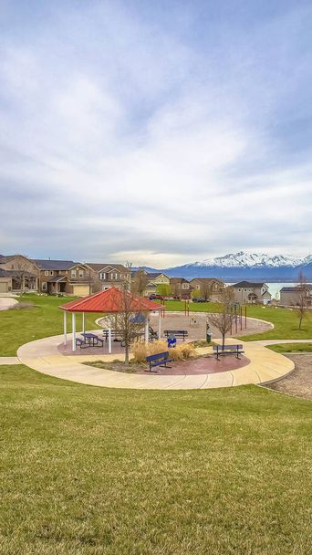 Panoramapark und Spielplatz inmitten von sattgrünem Rasen und schönen Häusern in der Nähe eines Sees - Foto, Bild