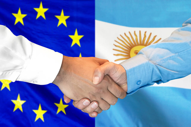 apretón de manos sobre Argentina y el fondo de la bandera de la Unión Europea
. - Foto, Imagen