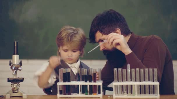 Teacher Helping Pupils Studying At Desks In Classroom. Back to school and home schooling. Teacher and kid. First school day. Young boy doing his school homework with his father. - Záběry, video