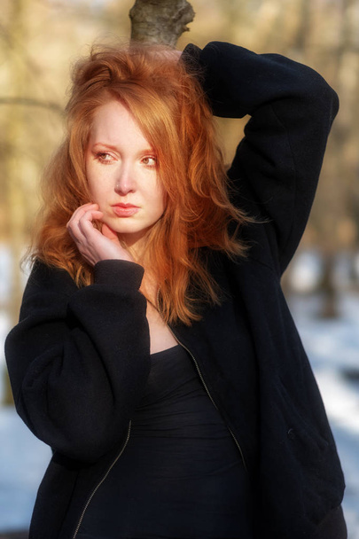 Jeune femme sexy aux cheveux roux, avec des vêtements noirs, est debout triste, déprimé, désespéré
 - Photo, image