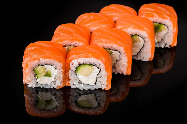 Sushi Roll - Maki Sushi collection de pièces avec oeufs de saumon, anguille fumée, concombre, fromage à la crème, sésame, avocat, frites d'oignon, viande de crabe, Tobiko isolé sur fond noir
. - Photo, image