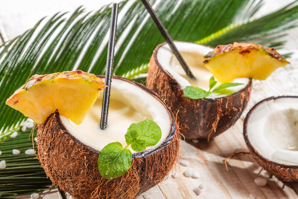 Pinacolada drink with mint served in a fresh coconut - Foto, afbeelding