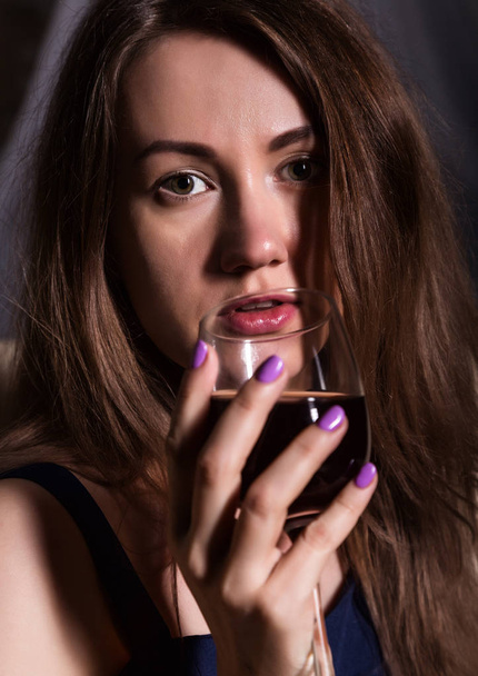 close-up of charming young woman drinks red wine - Фото, изображение