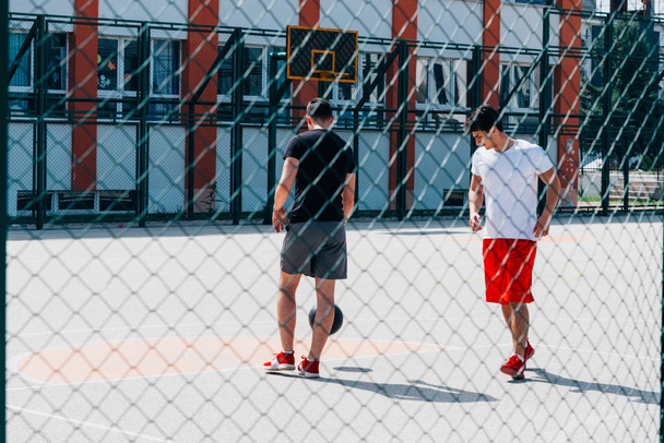 Two strong basketball player playing ball on an urban city baske - Fotografie, Obrázek