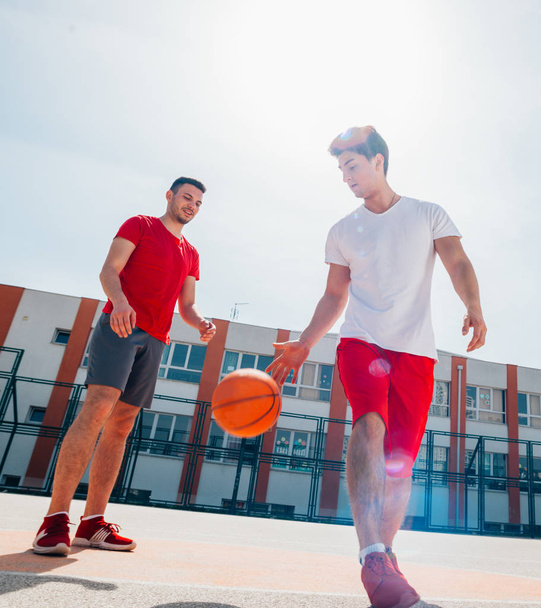 2人の白人バスケットボール選手がボールを手に入れるために戦う  - 写真・画像