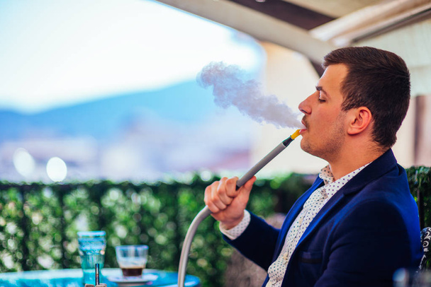Молодий бізнесмен у блістері і кальян для куріння хакі на с
 - Фото, зображення