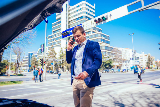 Молодой бизнесмен говорит по телефону, глядя под й
 - Фото, изображение