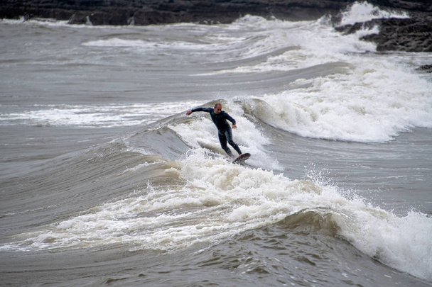 Surfista de mediana edad mostrando sus habilidades
 - Foto, Imagen