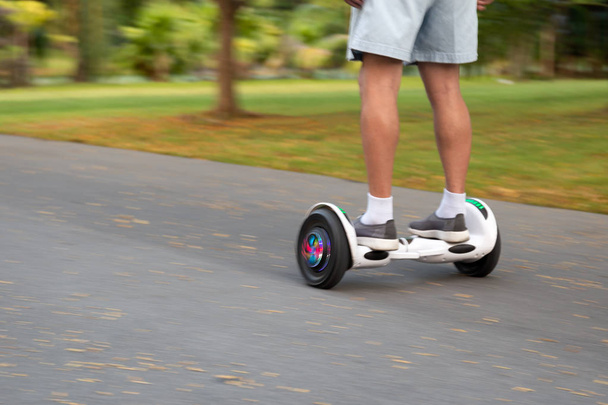 Concepto borroso Senior man play riding balance wheels on the road in the park
. - Foto, imagen