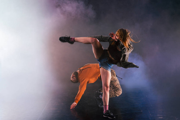 Το ζευγάρι του χορού δείχνει τις κινήσεις τους, το κορίτσι πετάει το πόδι της  - Φωτογραφία, εικόνα
