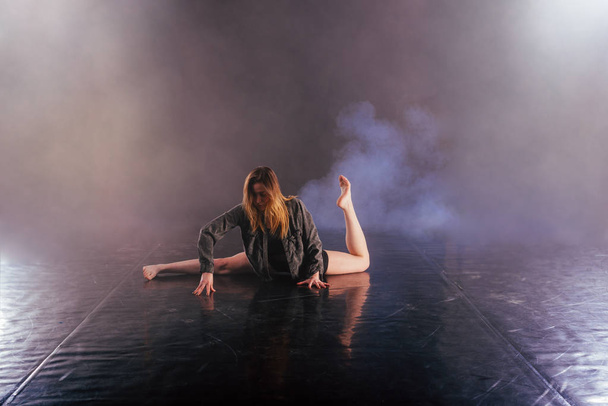 Shoeless vrouwelijke dans pronkt met haar moderne kunst dansmoves terwijl het kijken serieus en toegewijd. - Foto, afbeelding