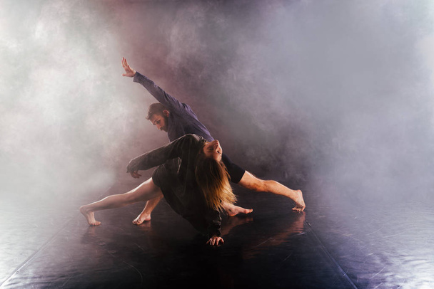 Современная танцевальная пара скручивает ноги и подтягивается близко к
  - Фото, изображение
