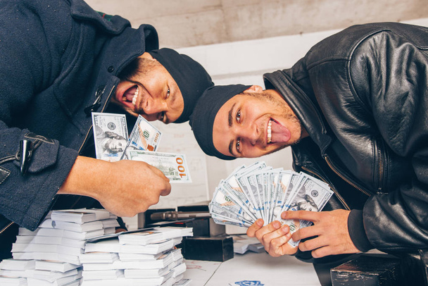 Οι άνδρες με μαύρο μετράνε τα χρήματα στο υπόγειο - Φωτογραφία, εικόνα