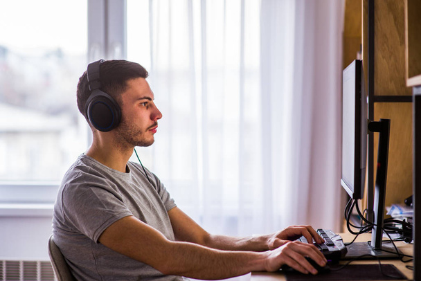 Красивый мужчина играет в компьютерные игры дома
 - Фото, изображение
