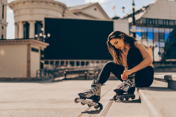 Patinagem mulher colocando patins em linha para patins
 - Foto, Imagem
