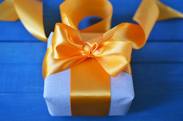 Gift box wrapped with craft paper and bow on neutral background with boke. Holiday concept. - Photo, Image
