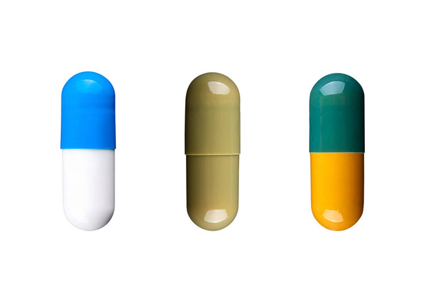 Tre capsule colorate isolate su sfondo bianco. Medicina
 - Foto, immagini