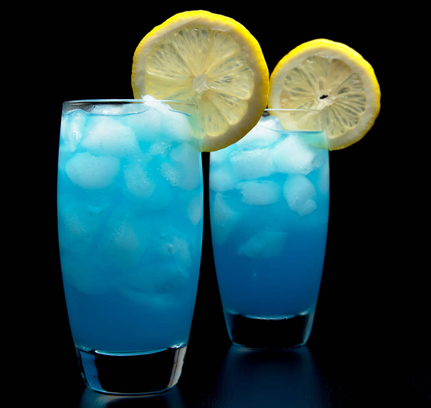 Blue lagoon cocktails with slice of lemon isolated on black - Photo, Image