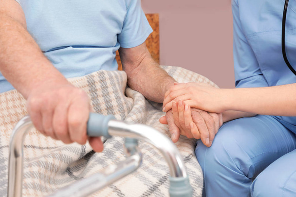 Nővér tartja vezető beteg kezét a kórházban, closeup. Orvosi segédkezés - Fotó, kép