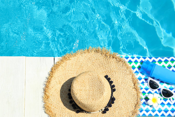 Flat lay composition with beach accessories on wooden deck near swimming pool. Space for text - Fotoğraf, Görsel