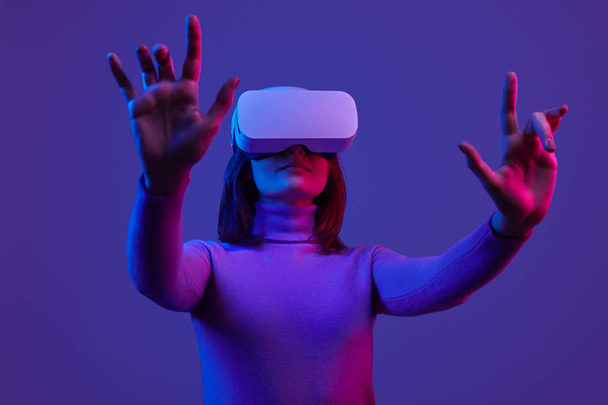 Woman in VR headset gesturing with hands - Фото, зображення