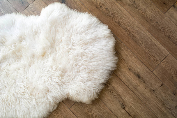Sheep skin on the laminate floor in the room. View from above - Photo, Image