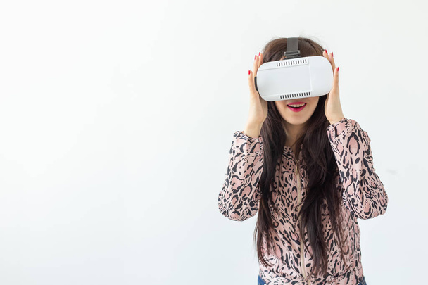 Genç kadın kopya alanı ile beyaz bir arka planda ayakta sanal gerçeklik gözlük ile bir film izliyor. Yeni özellikler ve modern teknoloji konsepti - Fotoğraf, Görsel