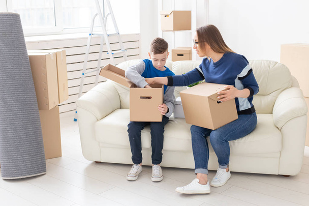 Bonito mãe e filho pequeno classificar caixas com coisas após a mudança. O conceito de habitação hipotecária e a alegria de novas habitações
. - Foto, Imagem