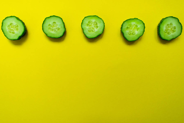 Slices cucumber bright yellow background. Background for the design of banners, websites, blogs. Copy space - Photo, Image