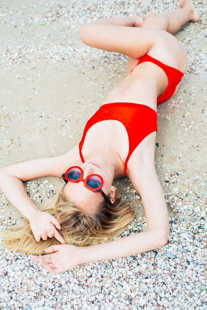 A beautiful young girl with long hair in a red swimsuit  relax on beach in the sea in sunny hot day - Fotoğraf, Görsel