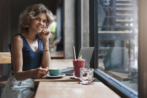 Charming successful young businesswoman working cafe restaurant sit near window enjoy tasty coffee smoothie use laptop prepare project, student studying before university exams - Foto, Imagen