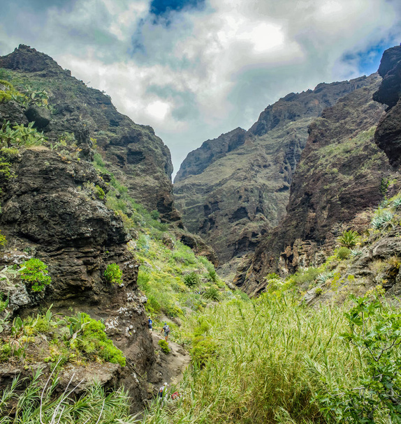 Rocks in the Masca gorge, Tenerife, showing solidified volcanic lava flow layers and arch formation. The ravine or barranco leads down to the ocean from a 900m altitude. - Photo, Image