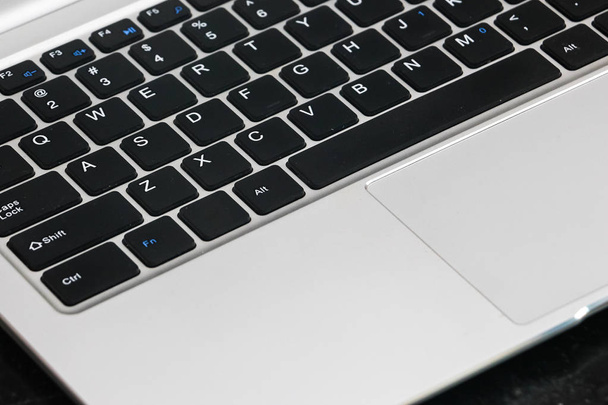 Closeup view of laptop keyboard on black background. - Zdjęcie, obraz