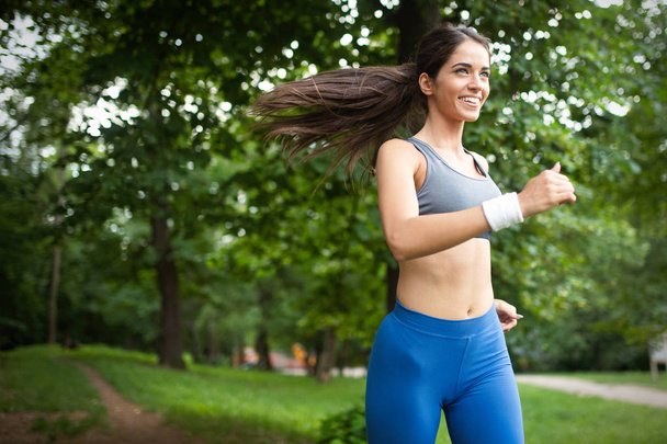 Healthy lifestyle image of young woman exercising outdoor - Foto, afbeelding