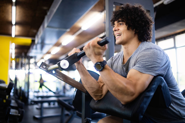 Fit healthy man exercising in modern gym - 写真・画像