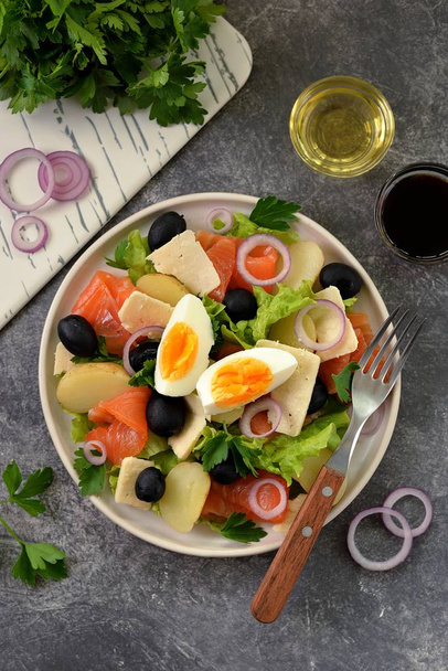 Salad with baby potatoes salted salmon, black olives, red onions, parmesan and lettuce. Organic healthy food. Top view.  - Photo, Image