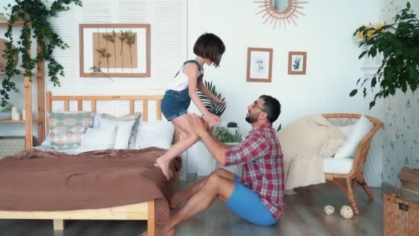 Girl jumping out of bed to daddys hands, slow motion - Footage, Video