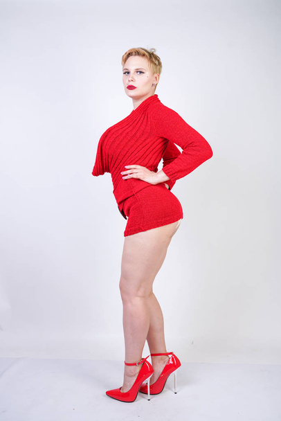 sexy plus size girl in erotic lingerie and red sweater posing on a white background in the Studio. hot young short hair woman with curvy body alone. - Foto, afbeelding