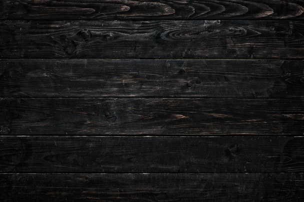 Horizontally arranged burnt boards. Black and brown wood texture with vignette. - Photo, image