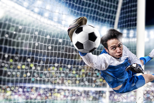 Bramkarz łapie piłkę na stadionie podczas meczu piłki nożnej. - Zdjęcie, obraz